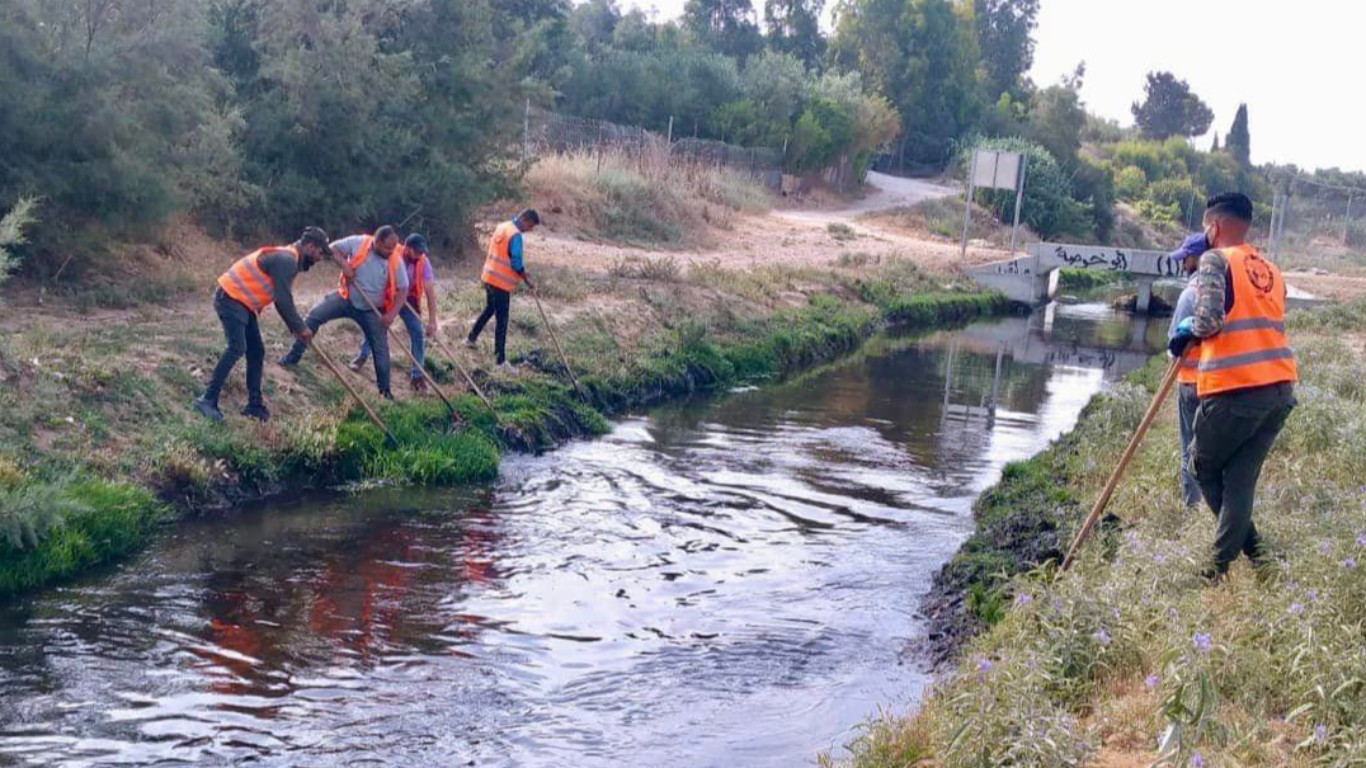 قسم الصحة والبيئة في بلدية البريج خلال إزالة الأعشاب العائمة، وتنظيف مجرى وادي غزة