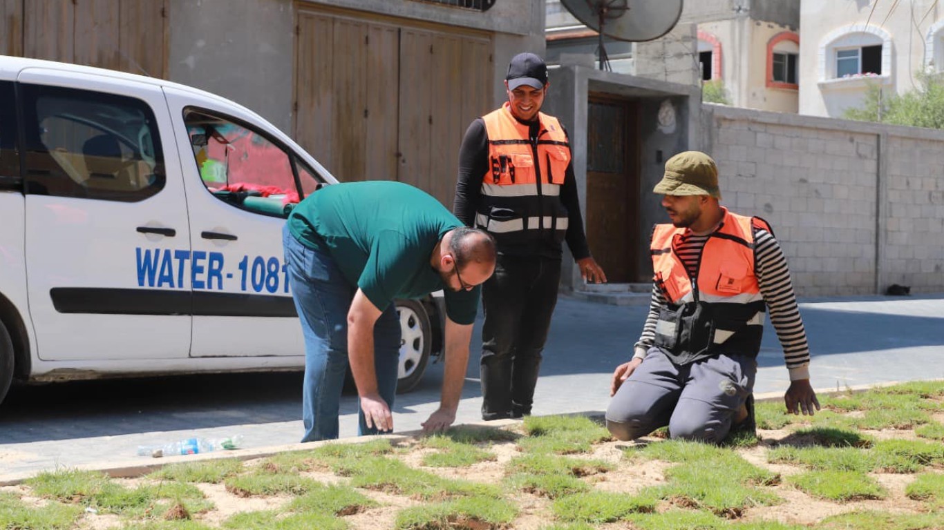 صناع الجمال في قسم الصحة والبيئة خلال أعمال استكمال زراعة العشب الأخضر في جزيرة شارع السكة